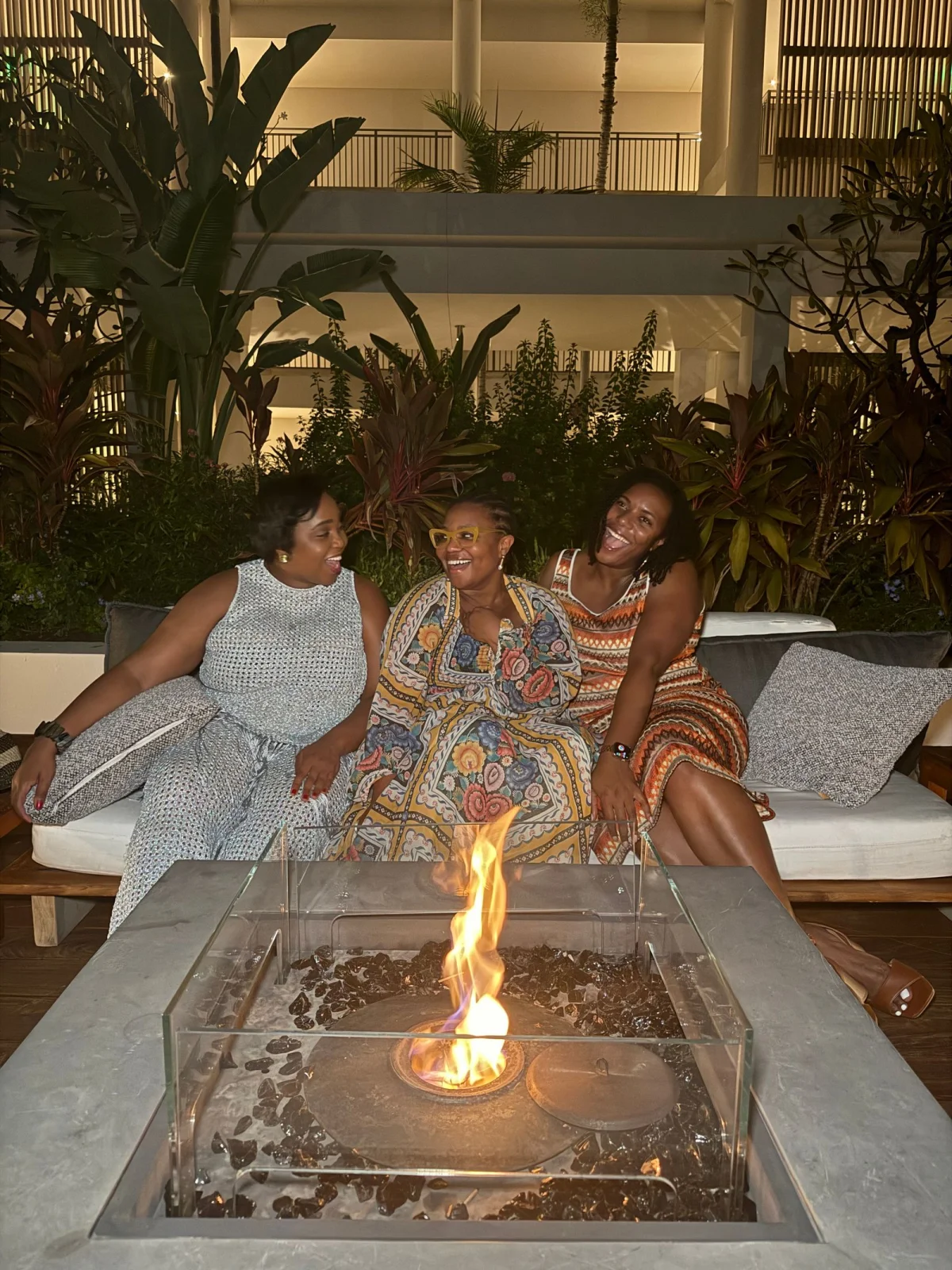 Three women chatting by a fire
