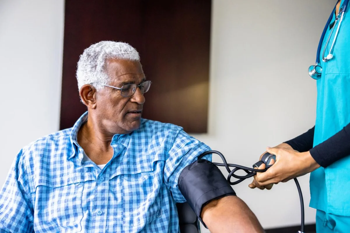 A nurse meeting with a senior black male patient