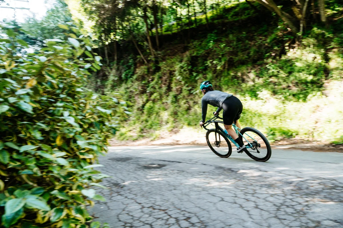 Bicyclist riding along a winding path in a wooded area. Bicyclist riding along a winding path in a wooded area.