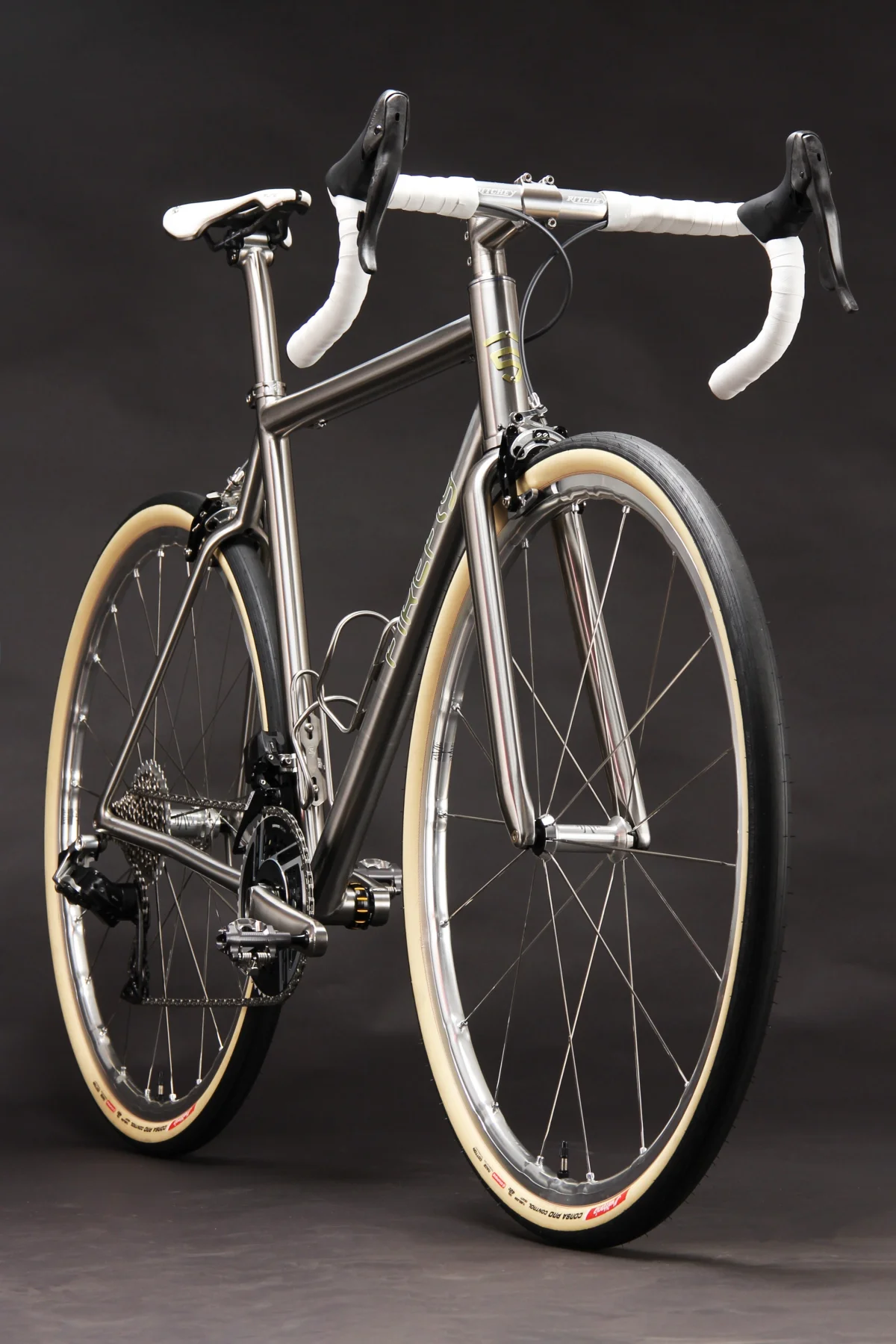 A sleek, modern bicycle with a metallic frame and white accent details set against a dark background. A sleek, modern bicycle with a metallic frame and white accent details set against a dark background.